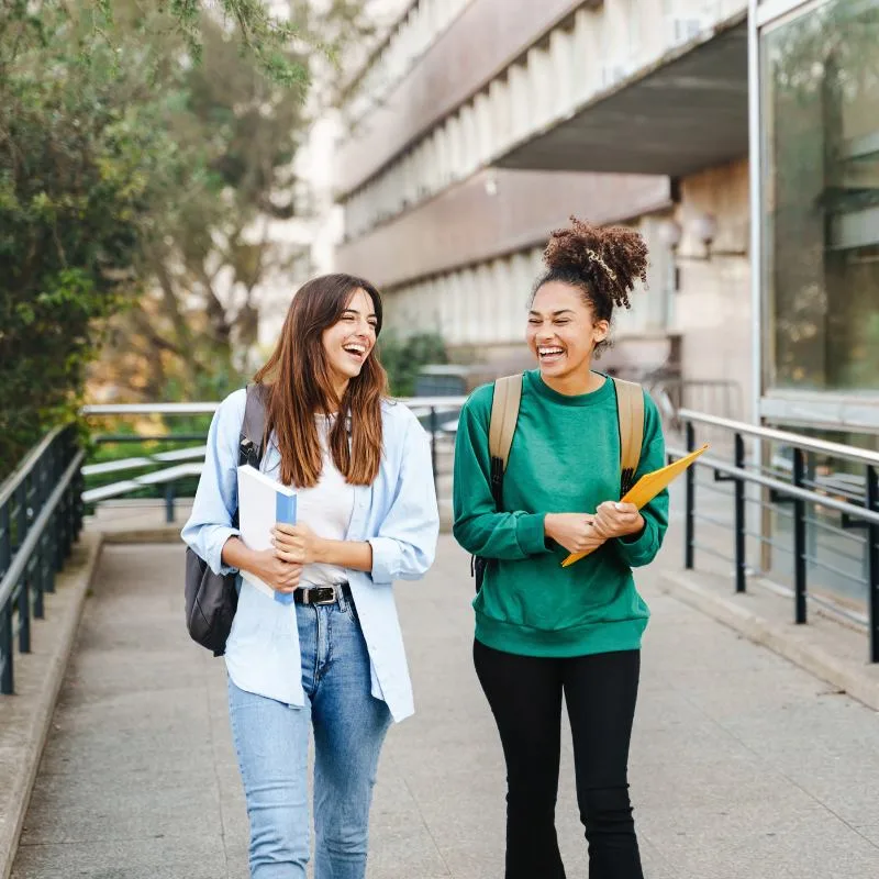 Two young women laughing together while out and about